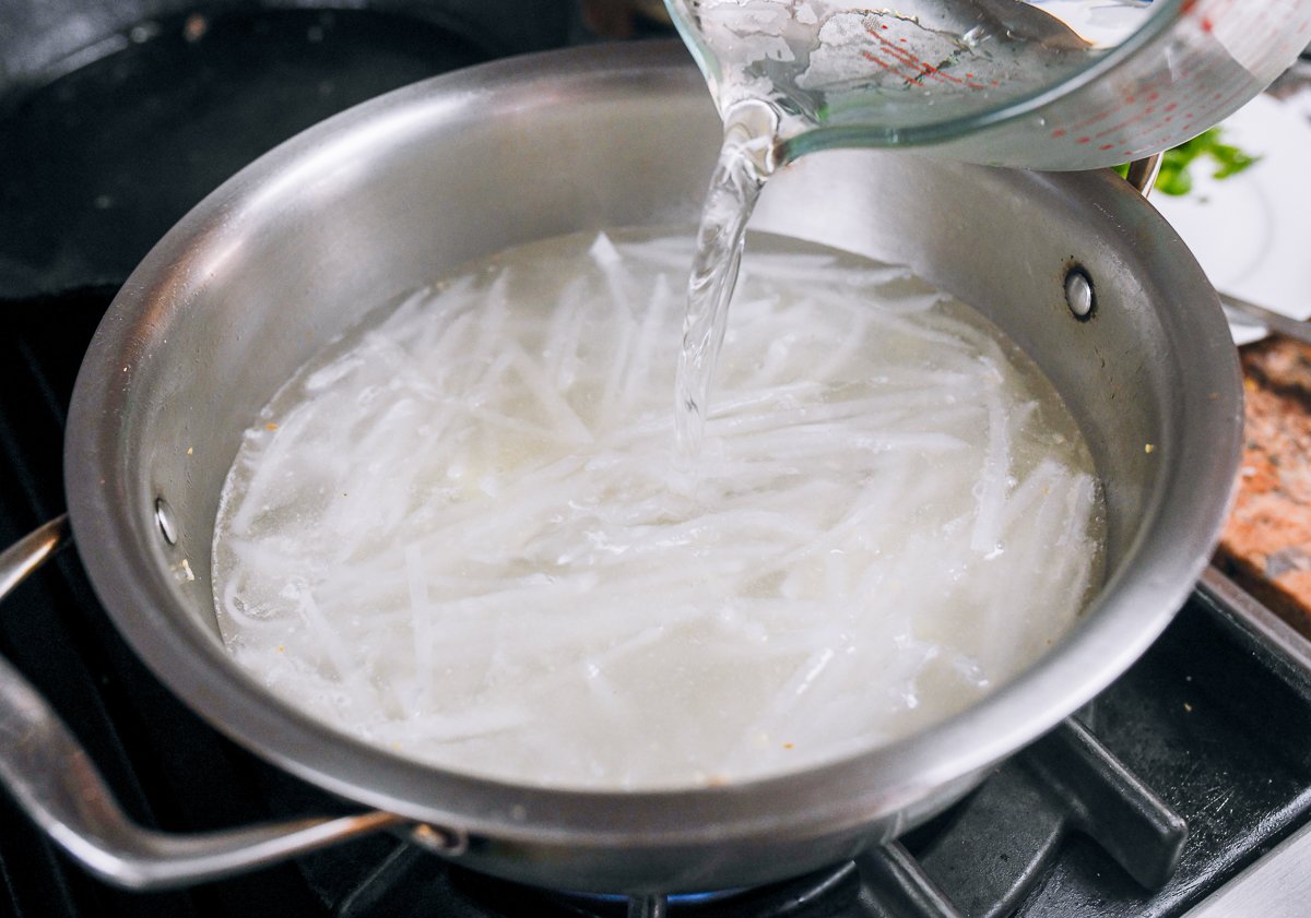 adding water to daikon radish in pot