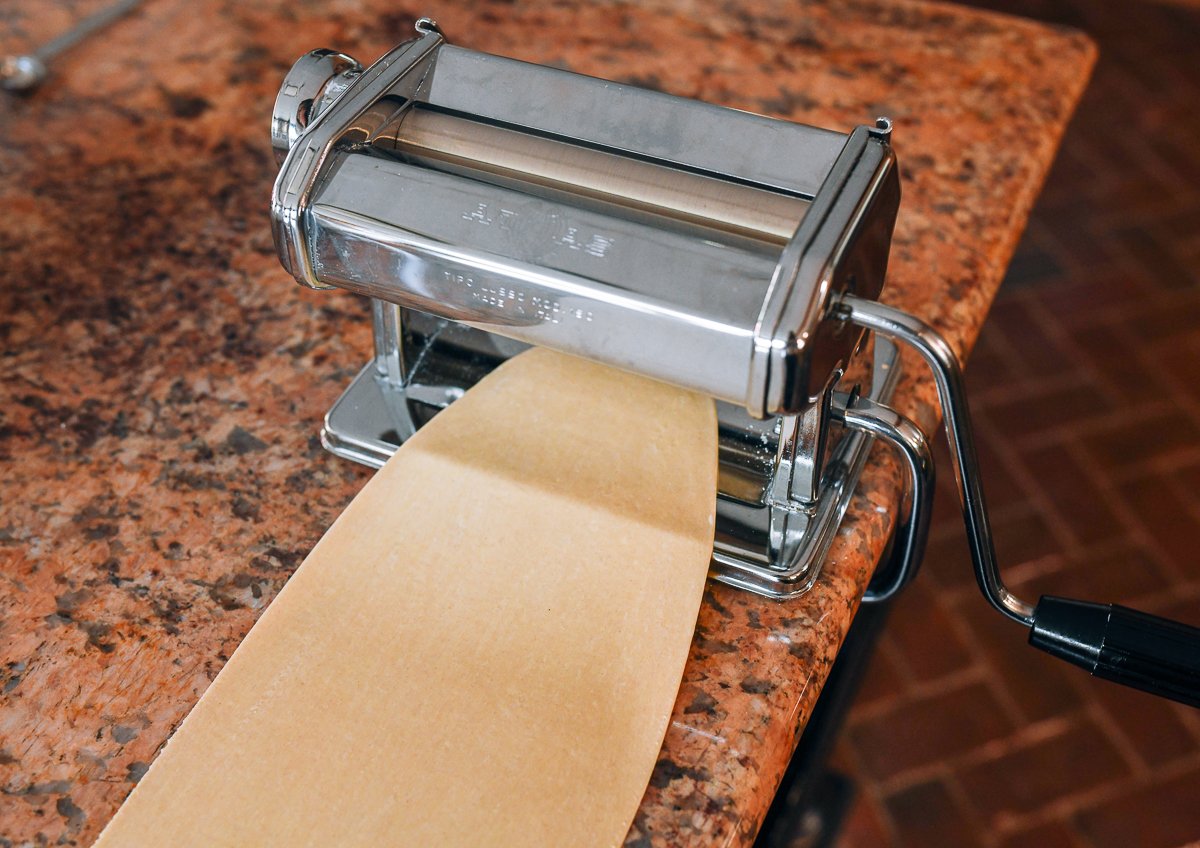 rolling dough sheet through pasta roller