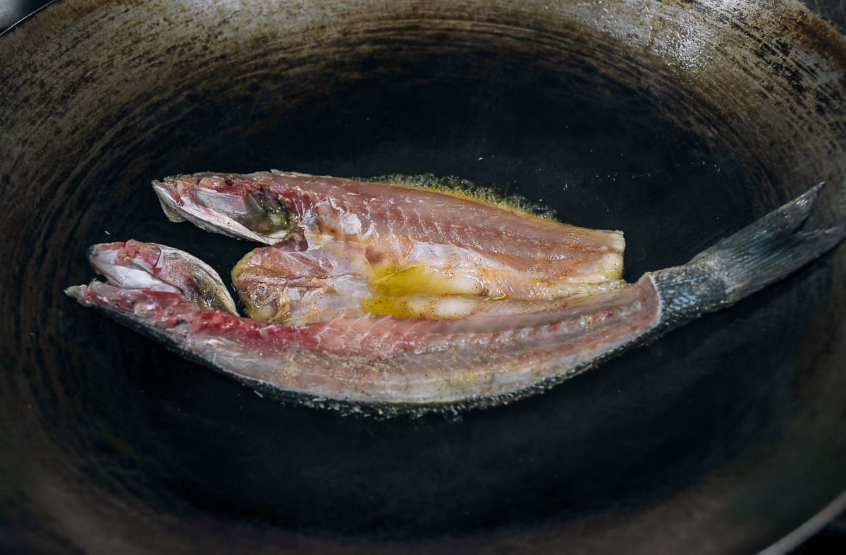pan-frying butterflied fish in wok