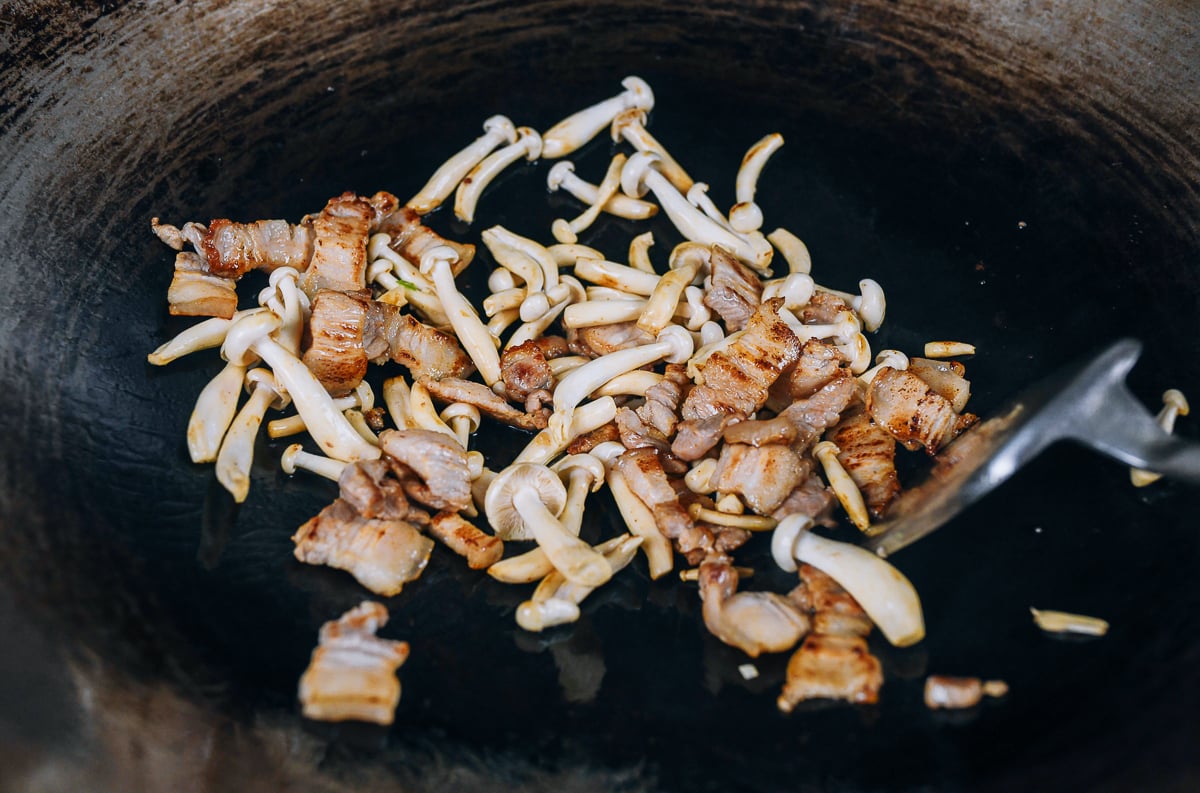 pork belly slices in wok with mushrooms