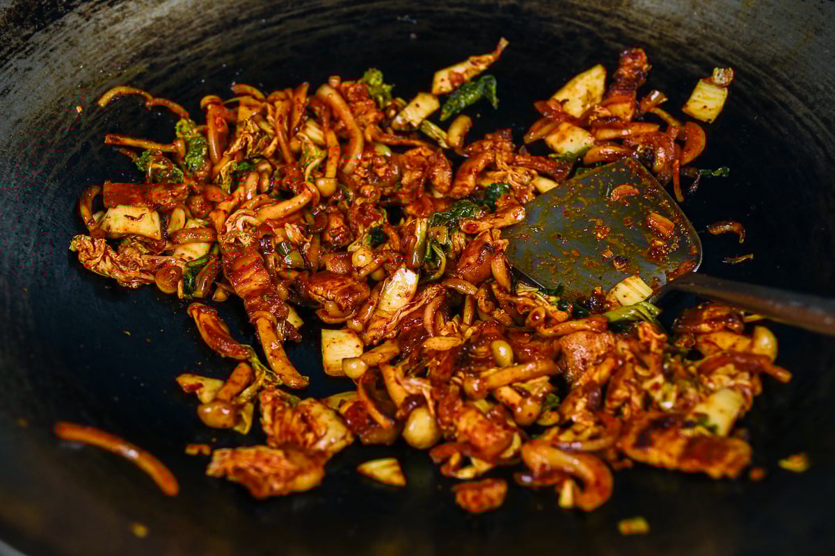 pork belly, kimchi, onion and mushroom mixture in wok