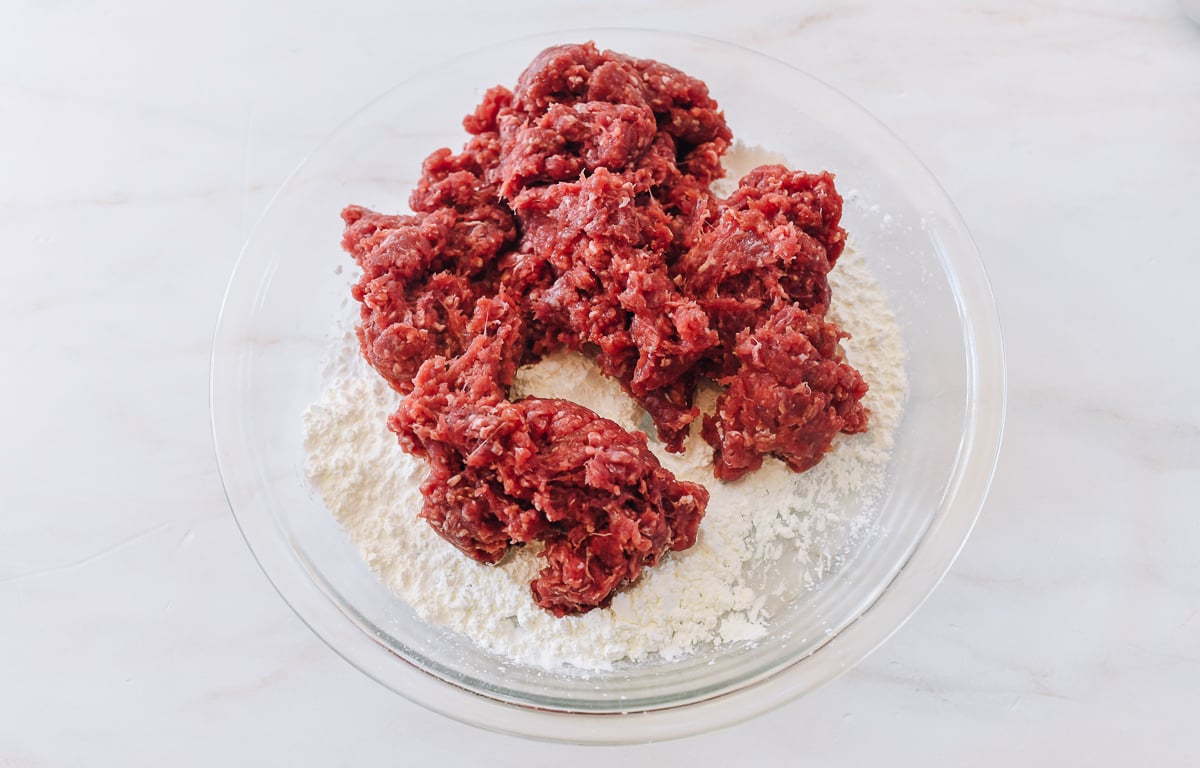 ground beef added to dish of cornstarch