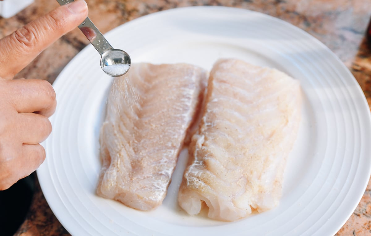 seasoning fish with salt